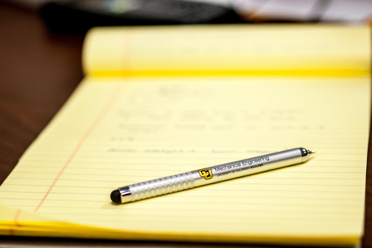 A pad of paper with a pen on top of it.