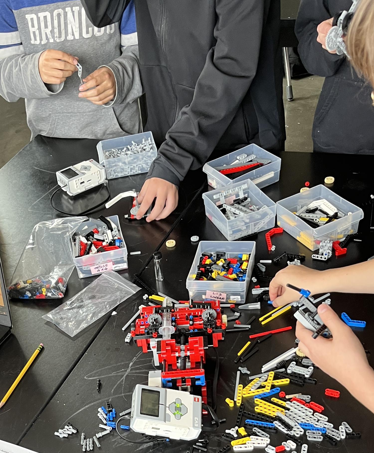 middle school kids playing with LEGO robots during a chemistry workshop