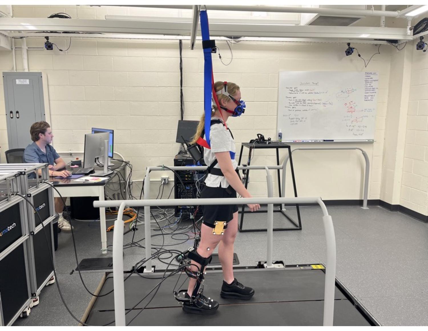 A woman walking on a treadmill pad in the Welker lab