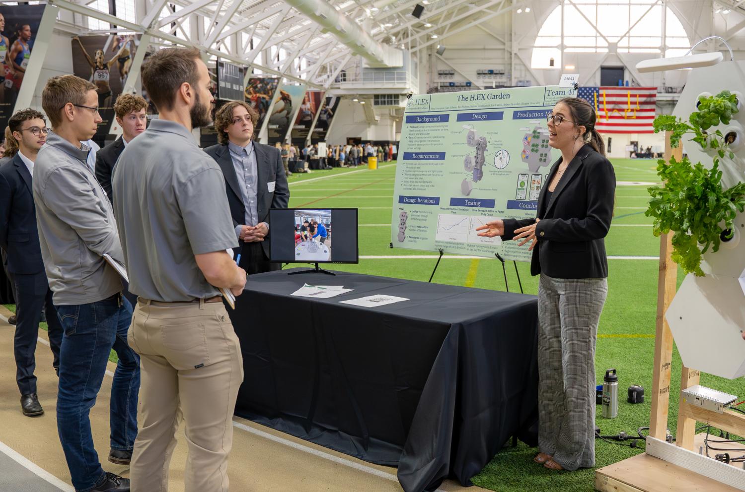 A student explains her team's HEX Garden project to judges at the 2023 Engineering Projects Expo