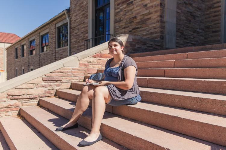 Lisa Tenorio sitting on steps on campus