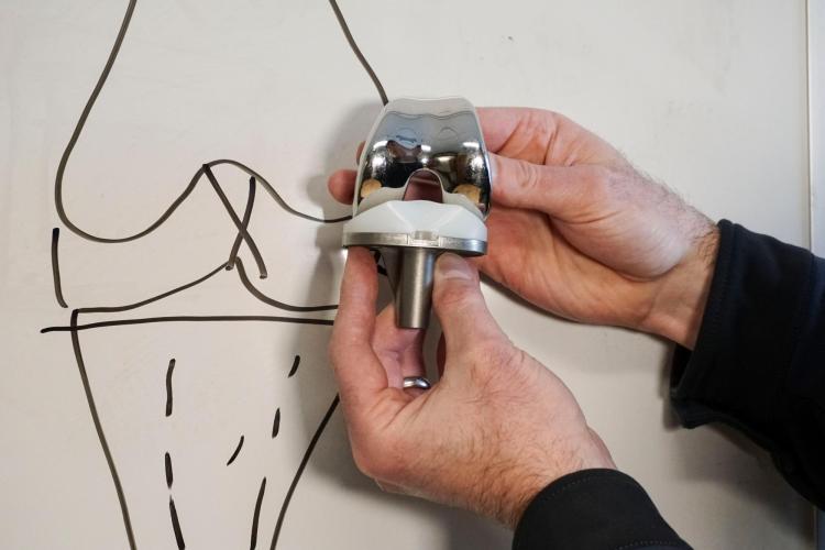 Knee replacement joint and diagram on whiteboard