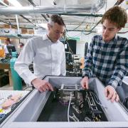 Greg Rieker (left) and a student discuss a project in their lab