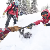 Avalanche dog rescuing a ski patrol member during training
