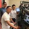 Ronggui Yang in a lab with two students.