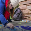 A student working with sidewalk chalk 