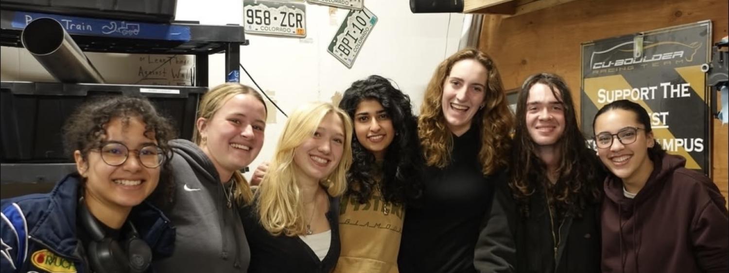 Group of women standing, leaning into each other and smiling for a photo
