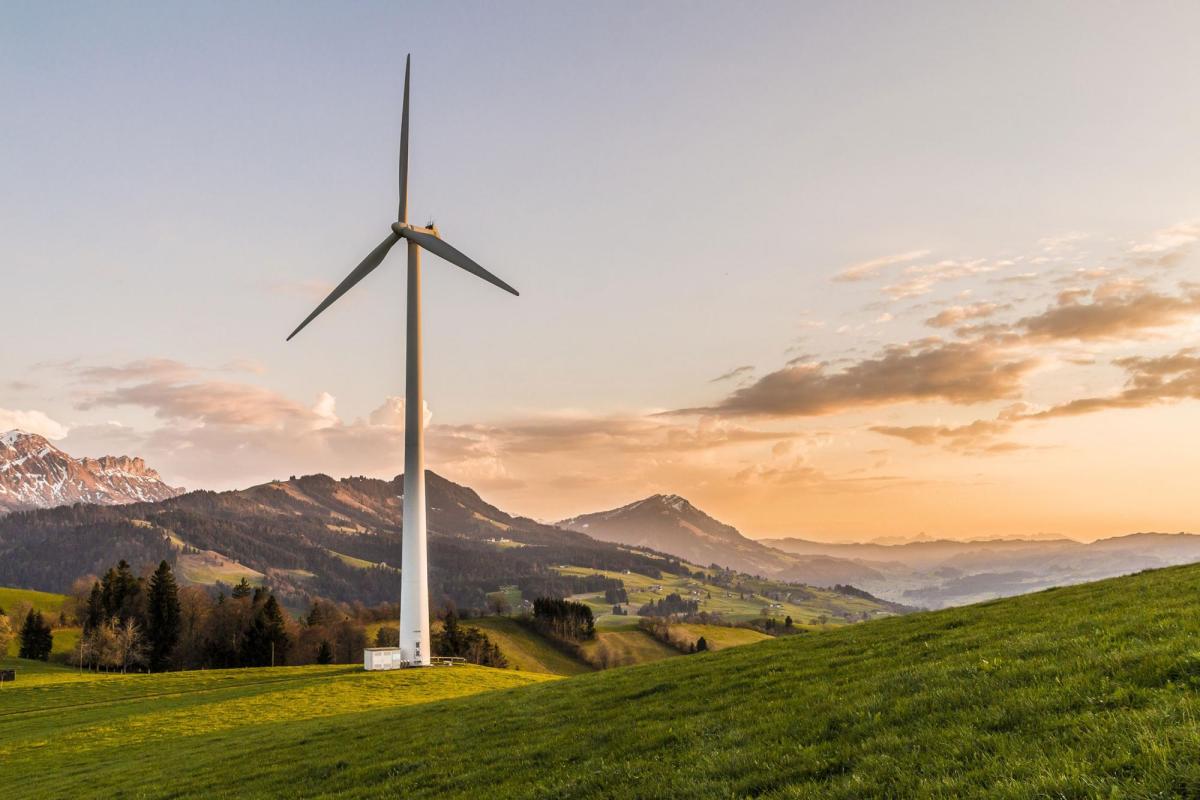 Single wind turbine with mountain backdrop