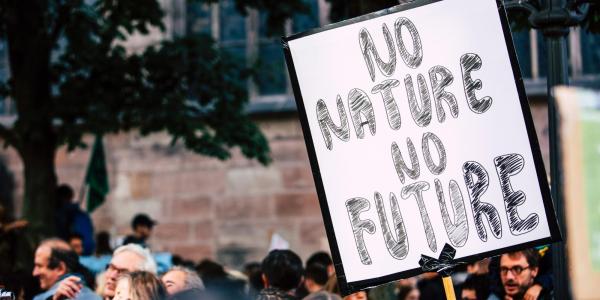 Crowd with someone holding a sign that says "No Nature, No Future"