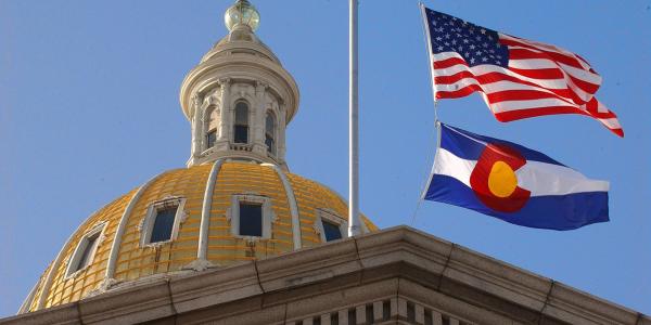 Colorado State Capitol with CO and US flags.