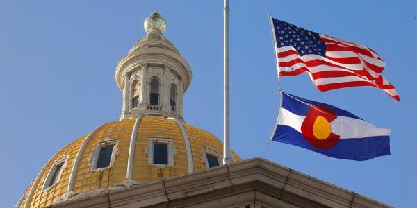 Colorado State Capitol with CO and US flags.