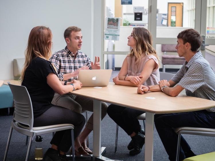 Students discussing at a table