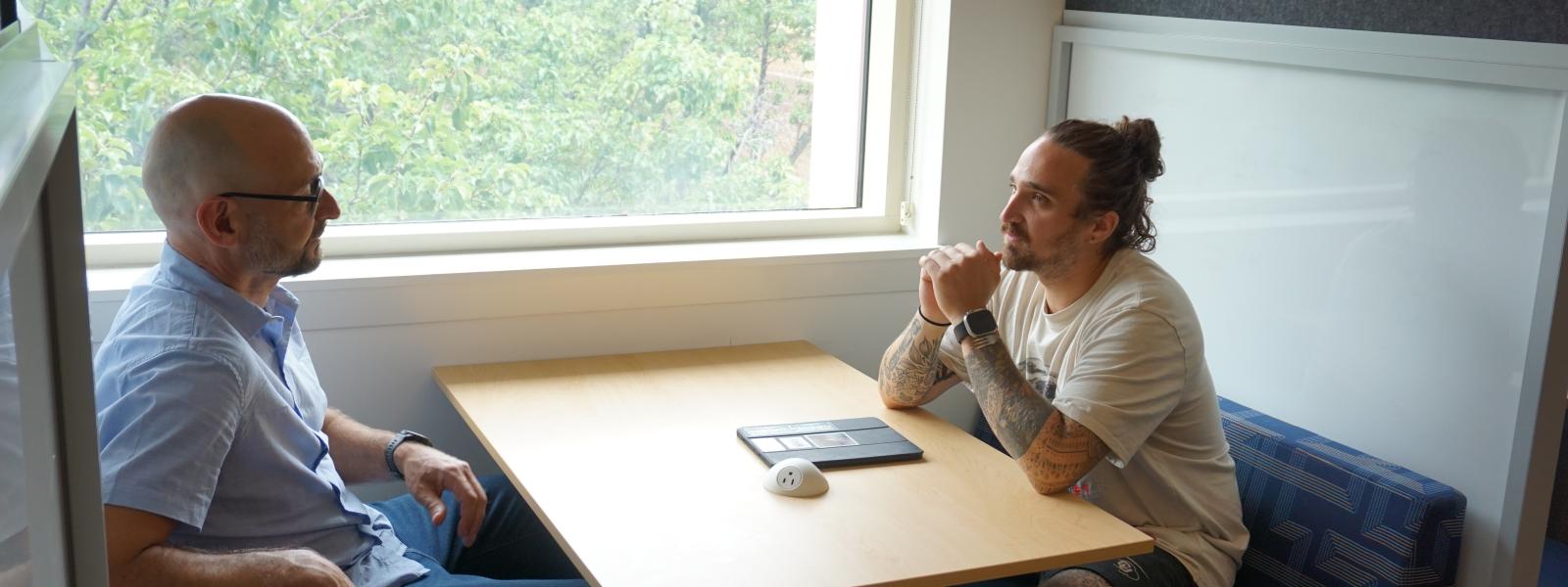 Student and Professor chatting at a table