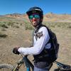Nicholas Kellaris on a mountain bike with helmet and sunglasses in the desert