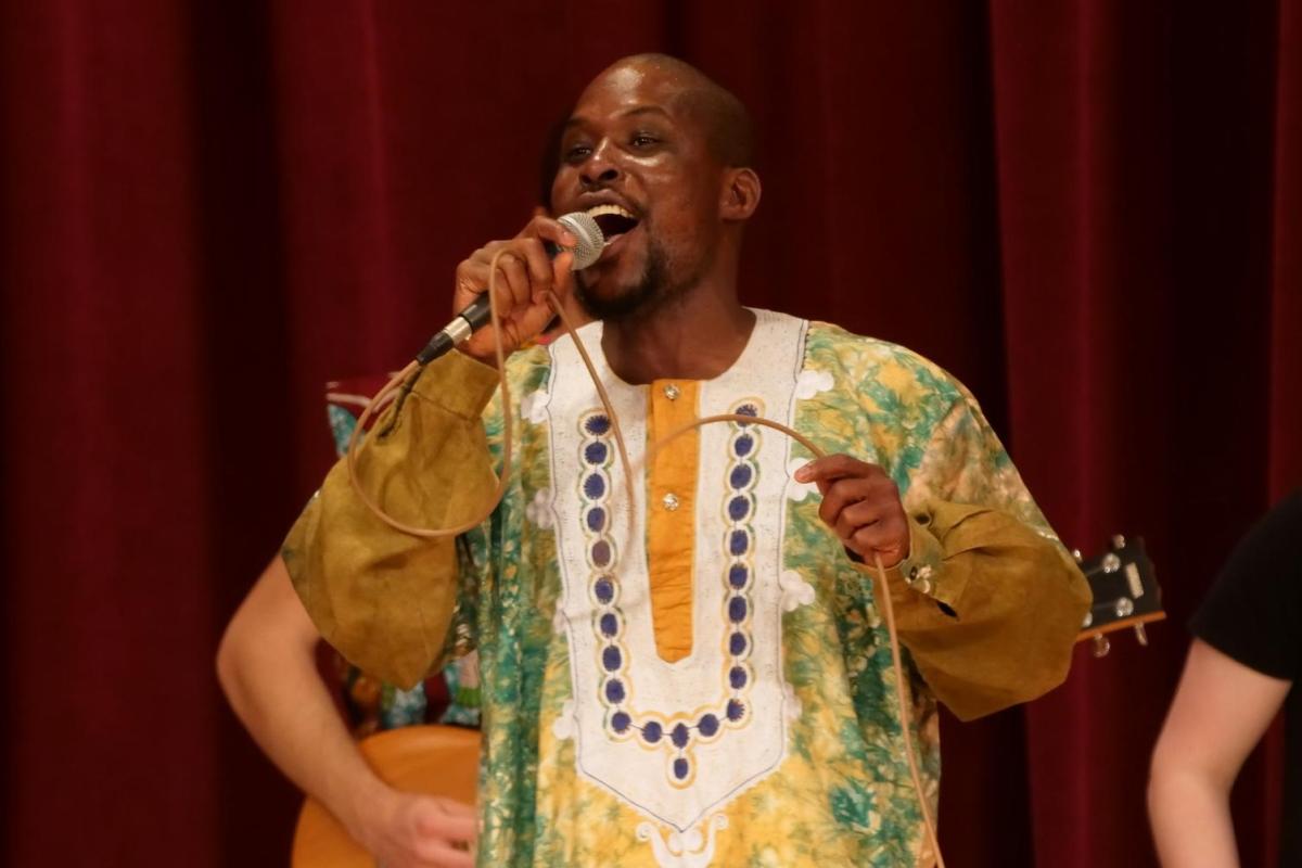african ensemble director on stage