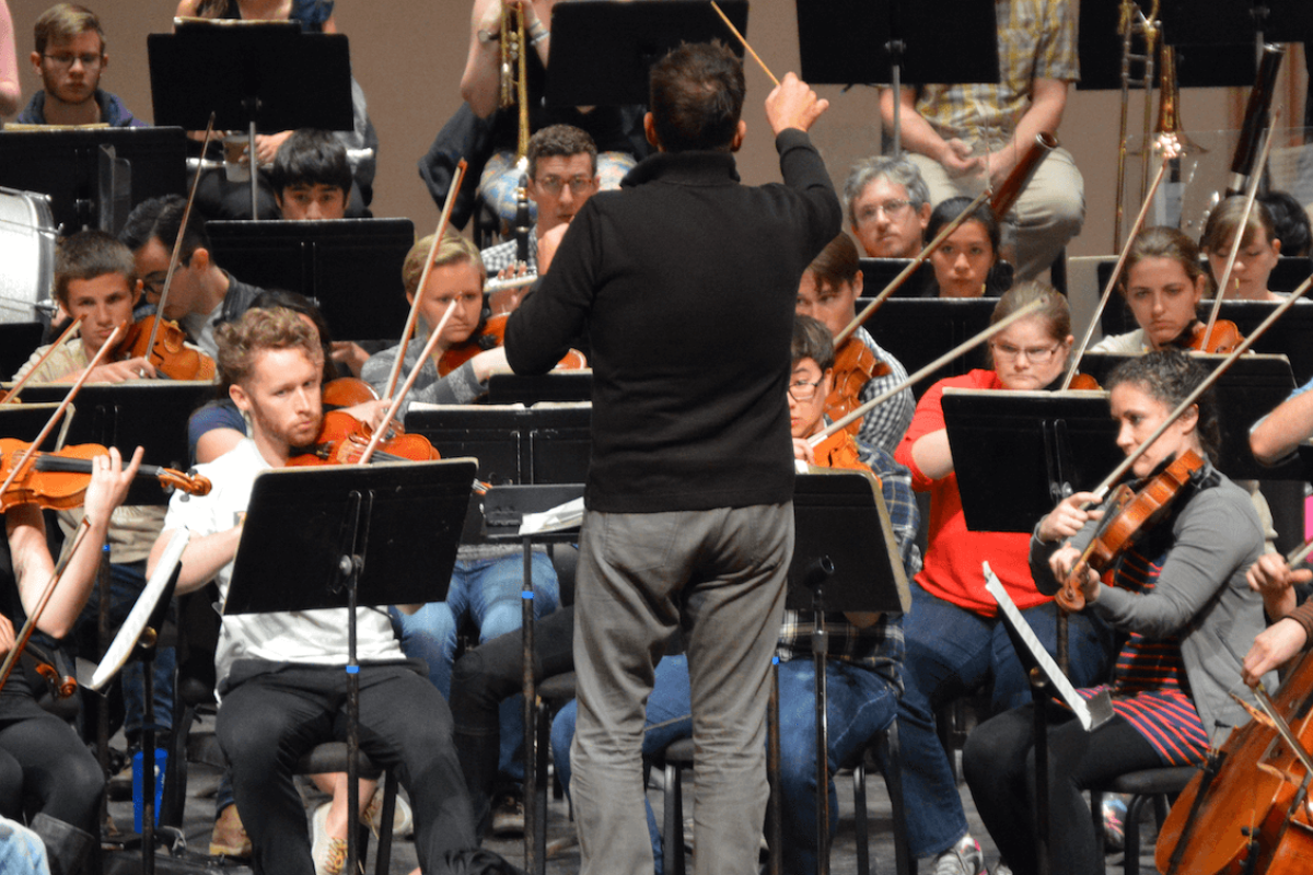 Conductor in front of symphony orchestra.