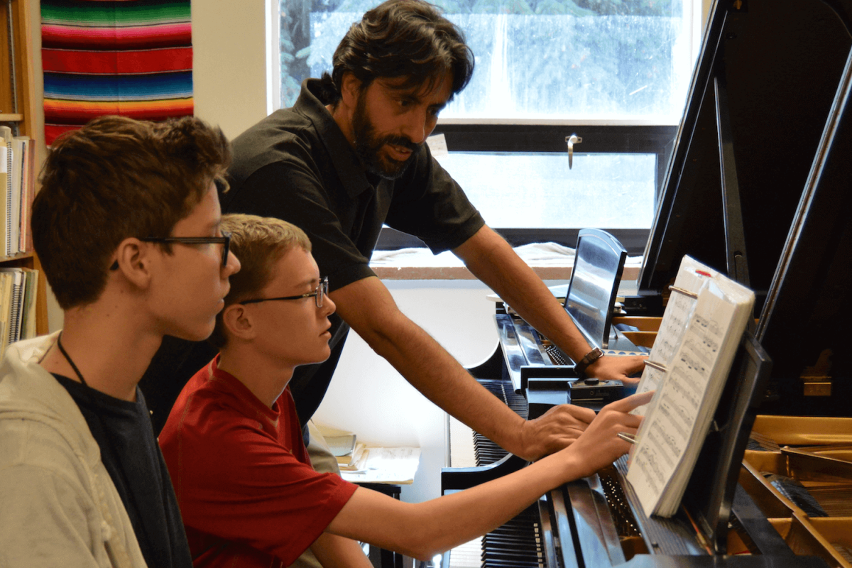 piano teacher working with young students