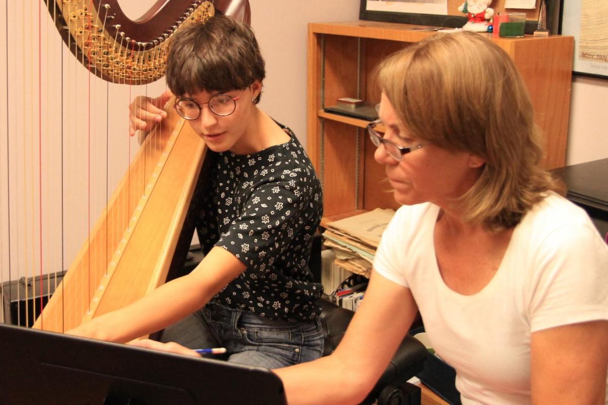 harp student getting a lesson from teacher