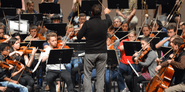 Conductor in front of symphony orchestra.