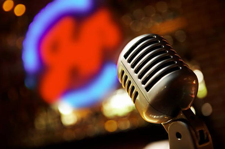Vintage microphone with blurred neon jazz sign in the background