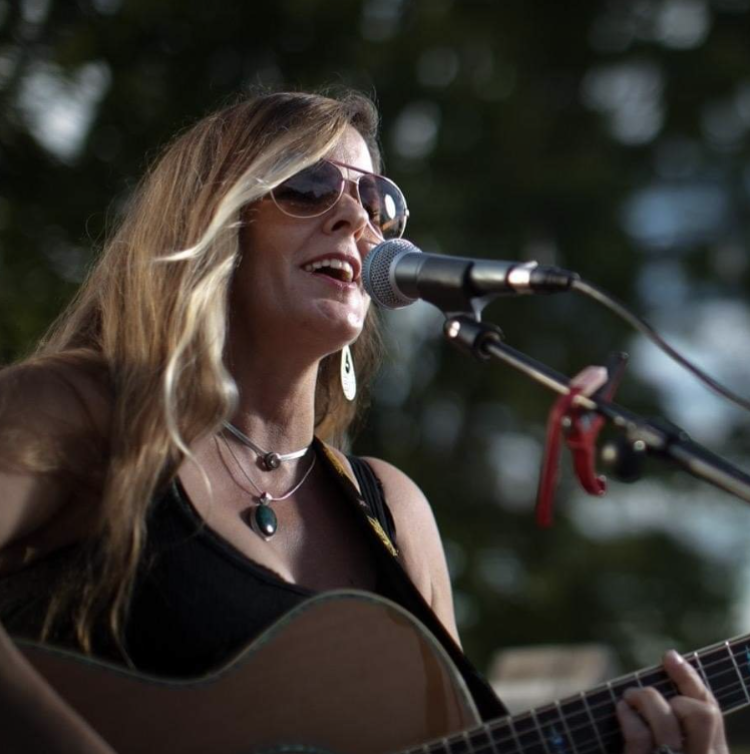 Mindy Watkins singing and playing guitar