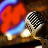 Vintage microphone with blurred neon jazz sign in the background