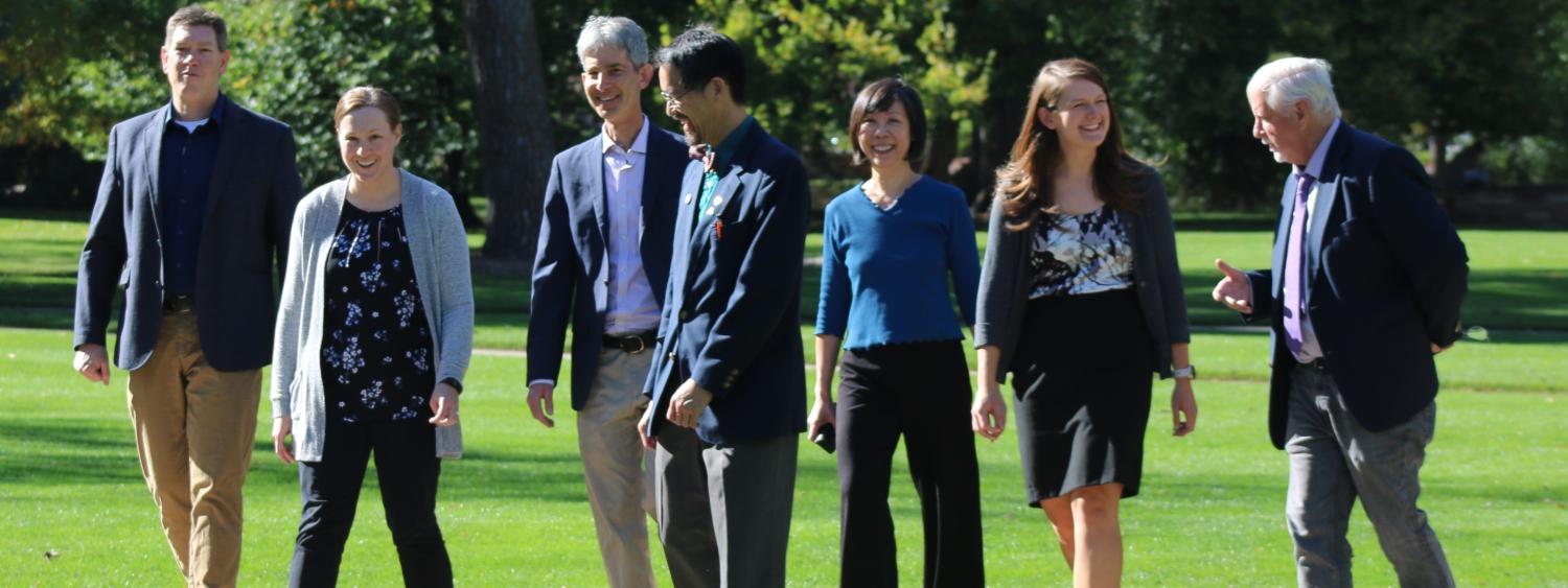 Theory faculty walking through park joyfully.