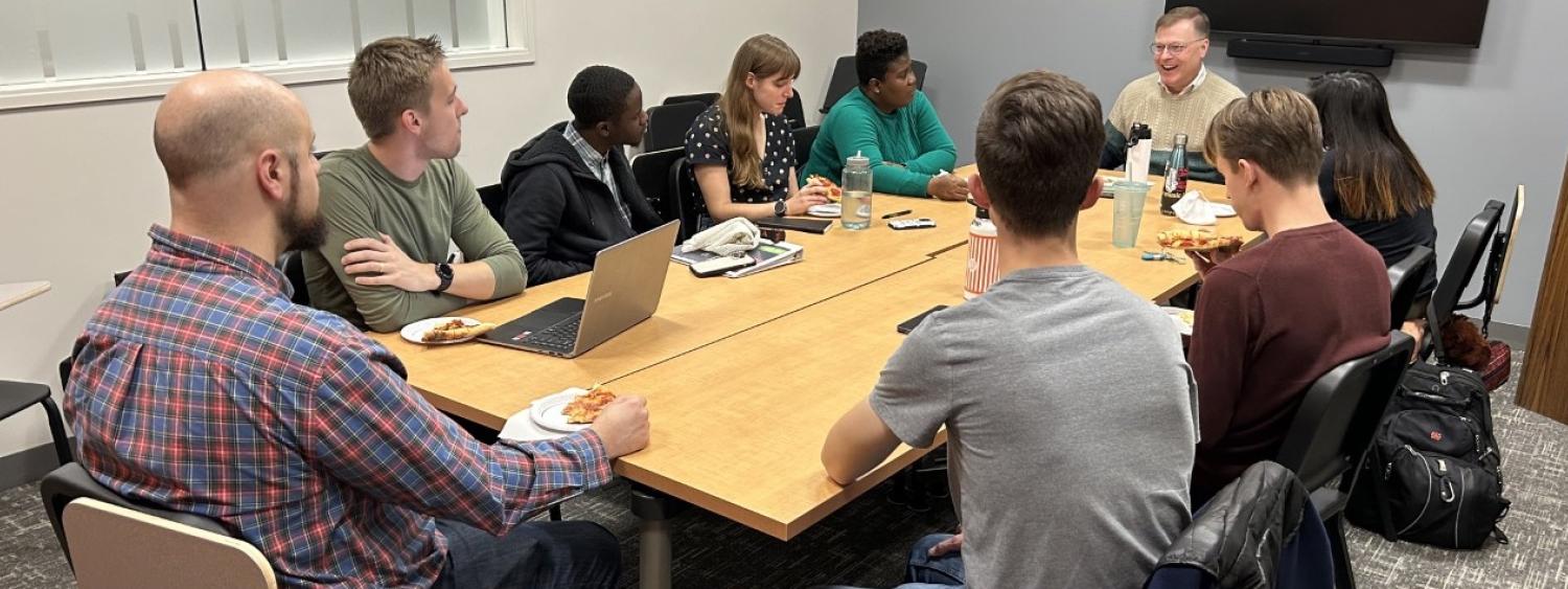 Students sitting around a conference table with professor