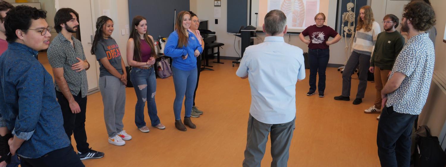 Musicians' Wellness students in semi-circle listening to professor explanation