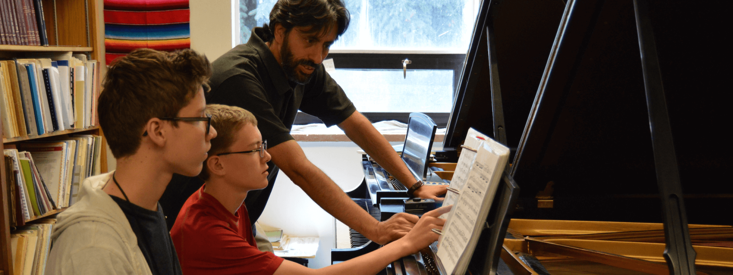 Piano pedagogy students working with teacher at the piano