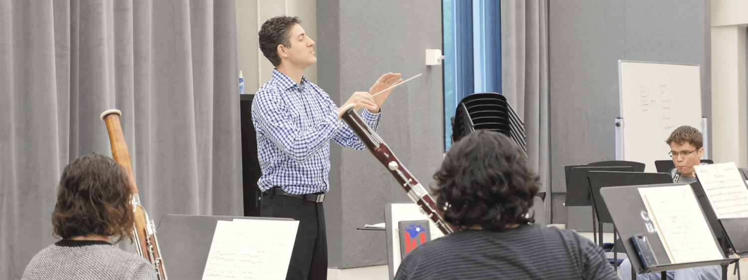 Wind ensemble students following conductor