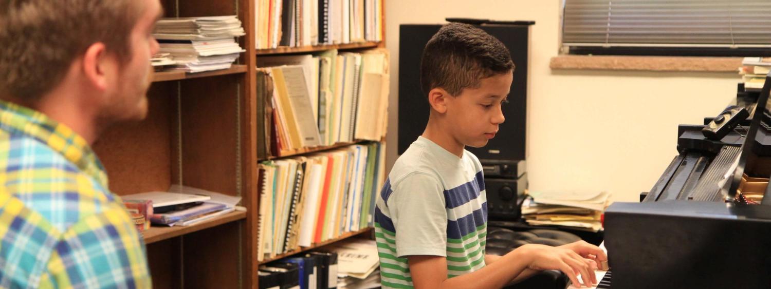 Youth piano program instructor teaching student