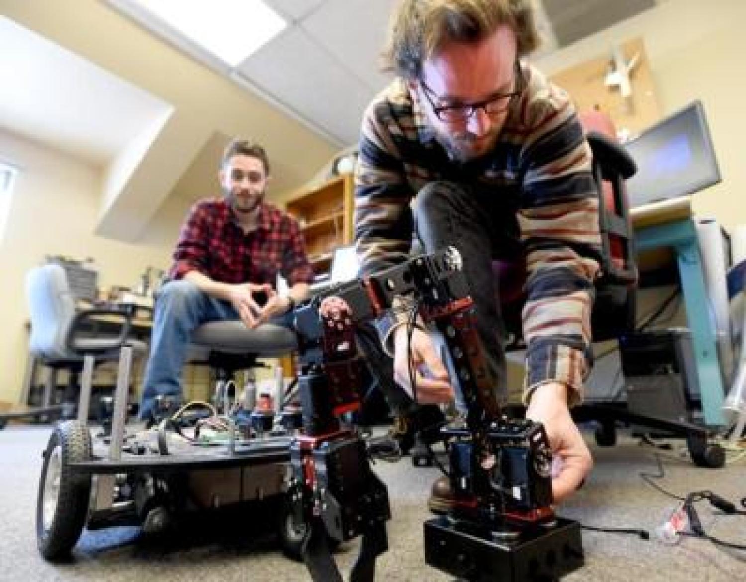 Seniors Benjamin Mellinkoff, left, and Matthew Spydell are getting their robot arm to work in their lab at the University of Colorado's Boulder campus on Wednesday.