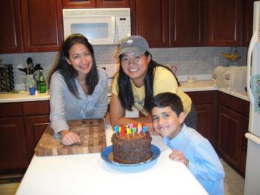 Alaa, Helen and her son around her birthday cake