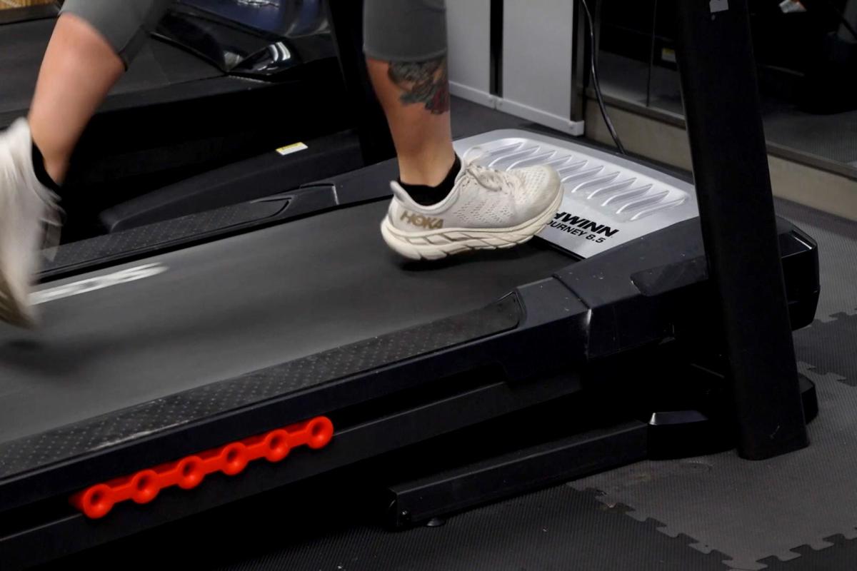 Photo of a person's feet and shoes as they run on an indoor treadmill.