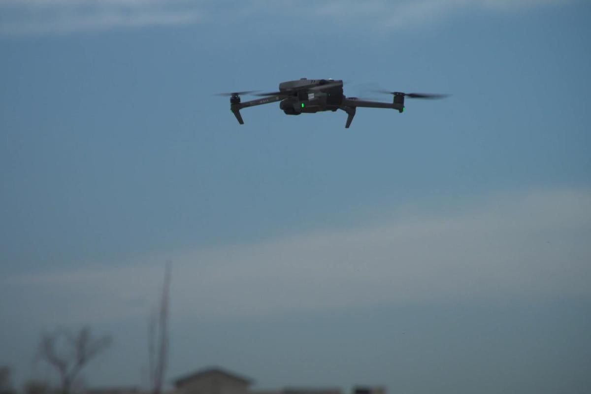 A drone mid-flight, with blue skies in the background.