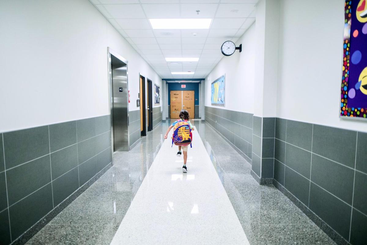 A boy running down the hall at school