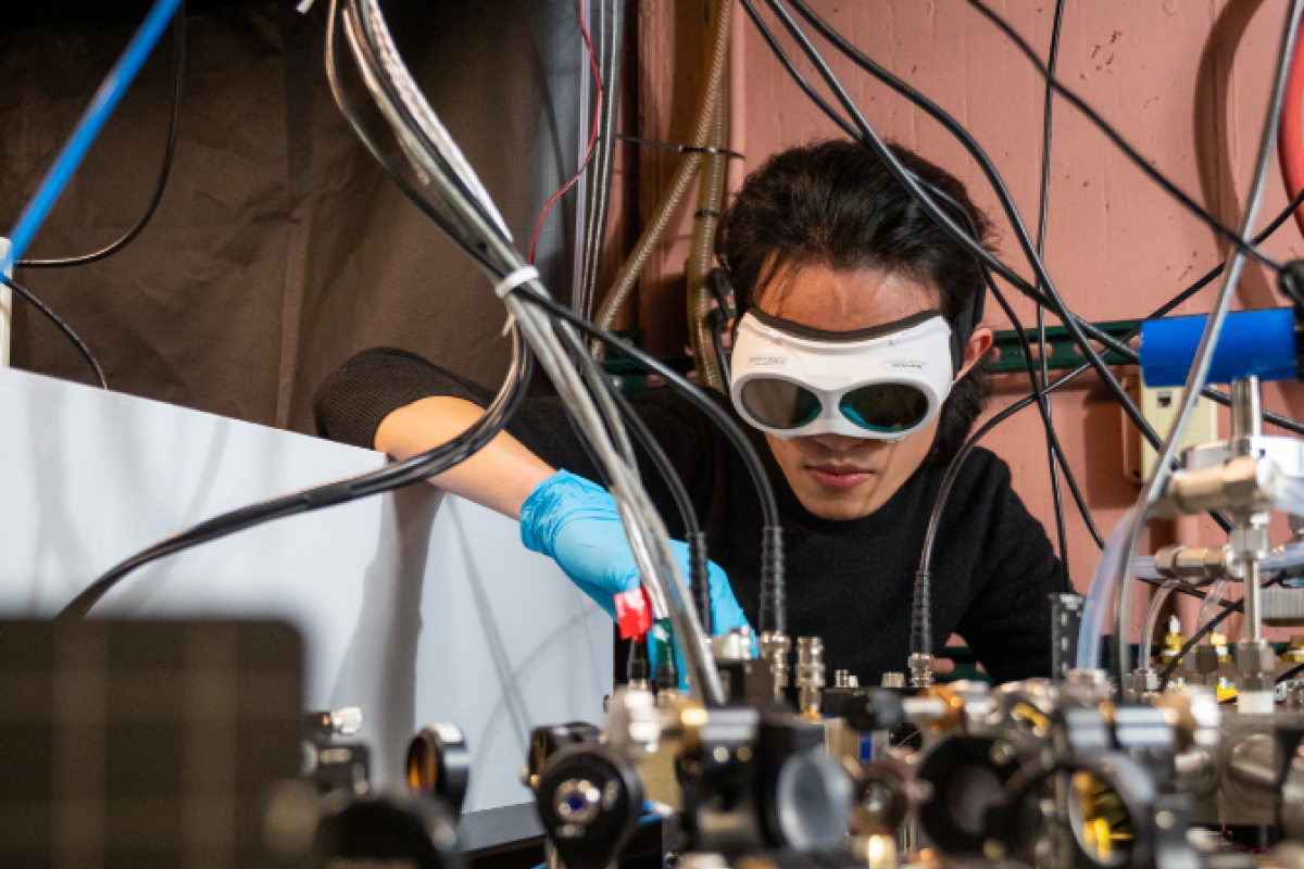 A person works on a project while wearing eye protection.