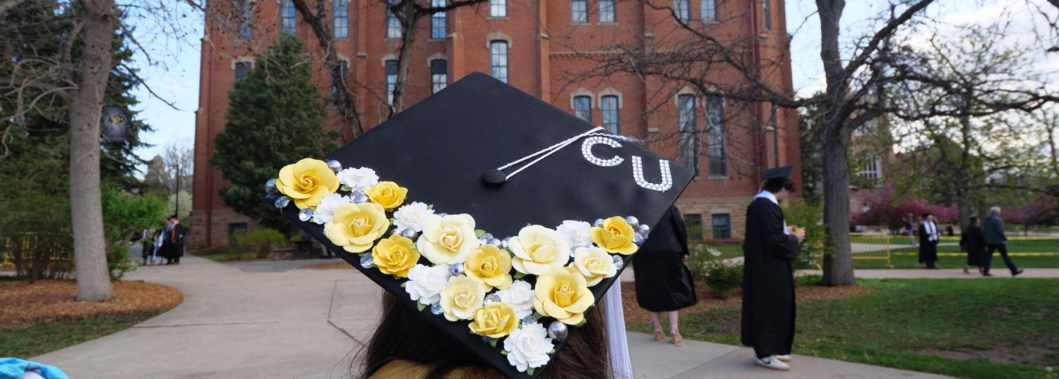 A student with a decorated graduation cap on their head.