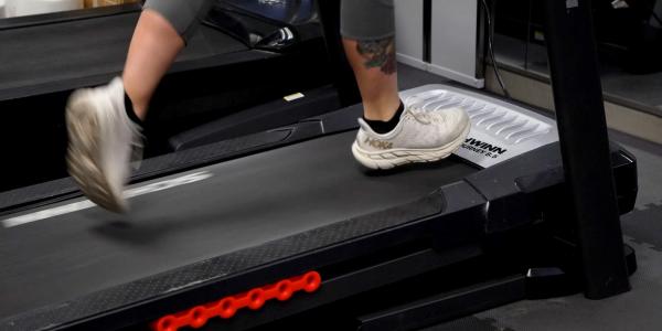 Photo of a person's feet and shoes as they run on an indoor treadmill. 