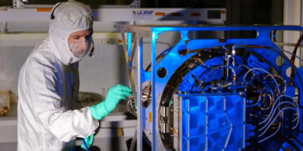 Engineer inspects the Interstellar Dust Experiment (IDEX) instrument. 