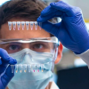 Man examines a vial in a lab