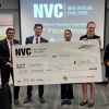 Team stands with giant prize check