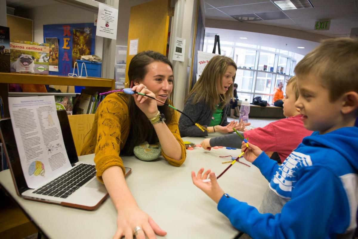 a woman instructs a young boy how to read a chart