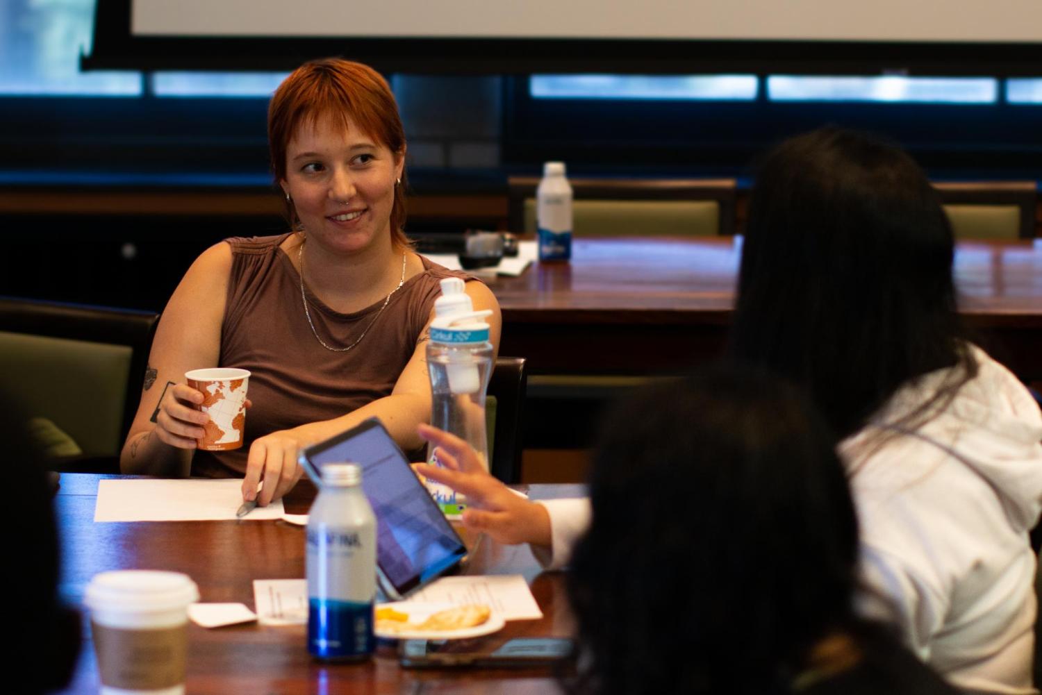 two young people sit at a table and chat with each other
