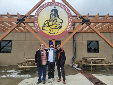 Student from the Native Voices program stand in front of the Turtle Mountain Community School in South Dakota