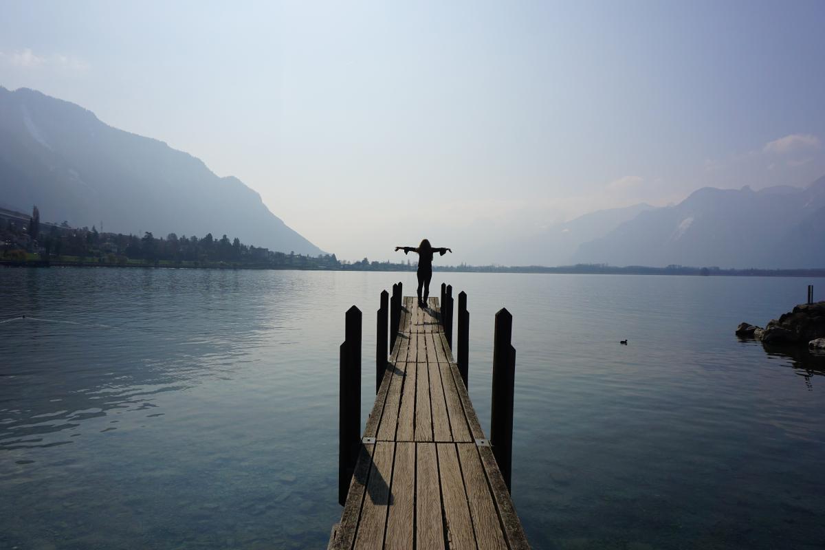 Student on end of dock looking at view of Swiss lake