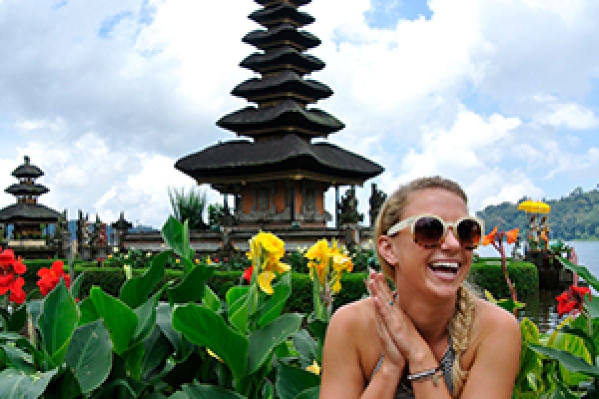 Student sitting in front of an Indonesian shrine and tulips