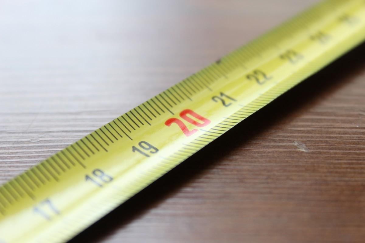 yellow tape measure extended, laying flat on table top