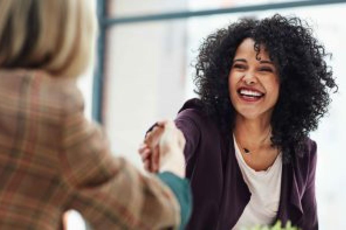 Two people shaking hands and smiling.